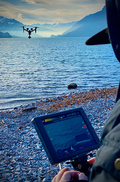 Drone en vol au dessus d'un lac avec son pilote 